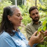 Woman and man look at leaves for weed management.