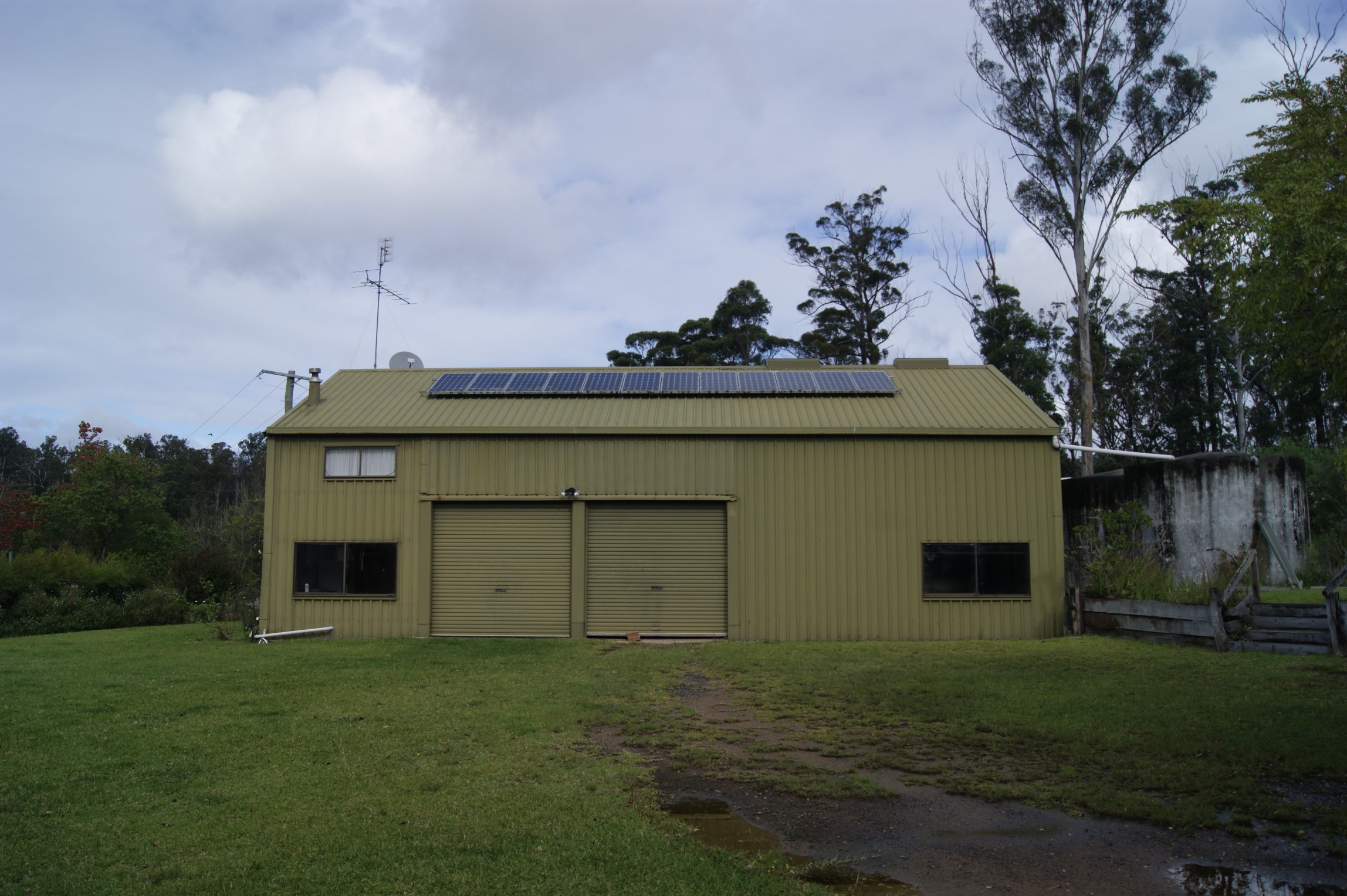 A front view of the olive coloured shed with two garage doors