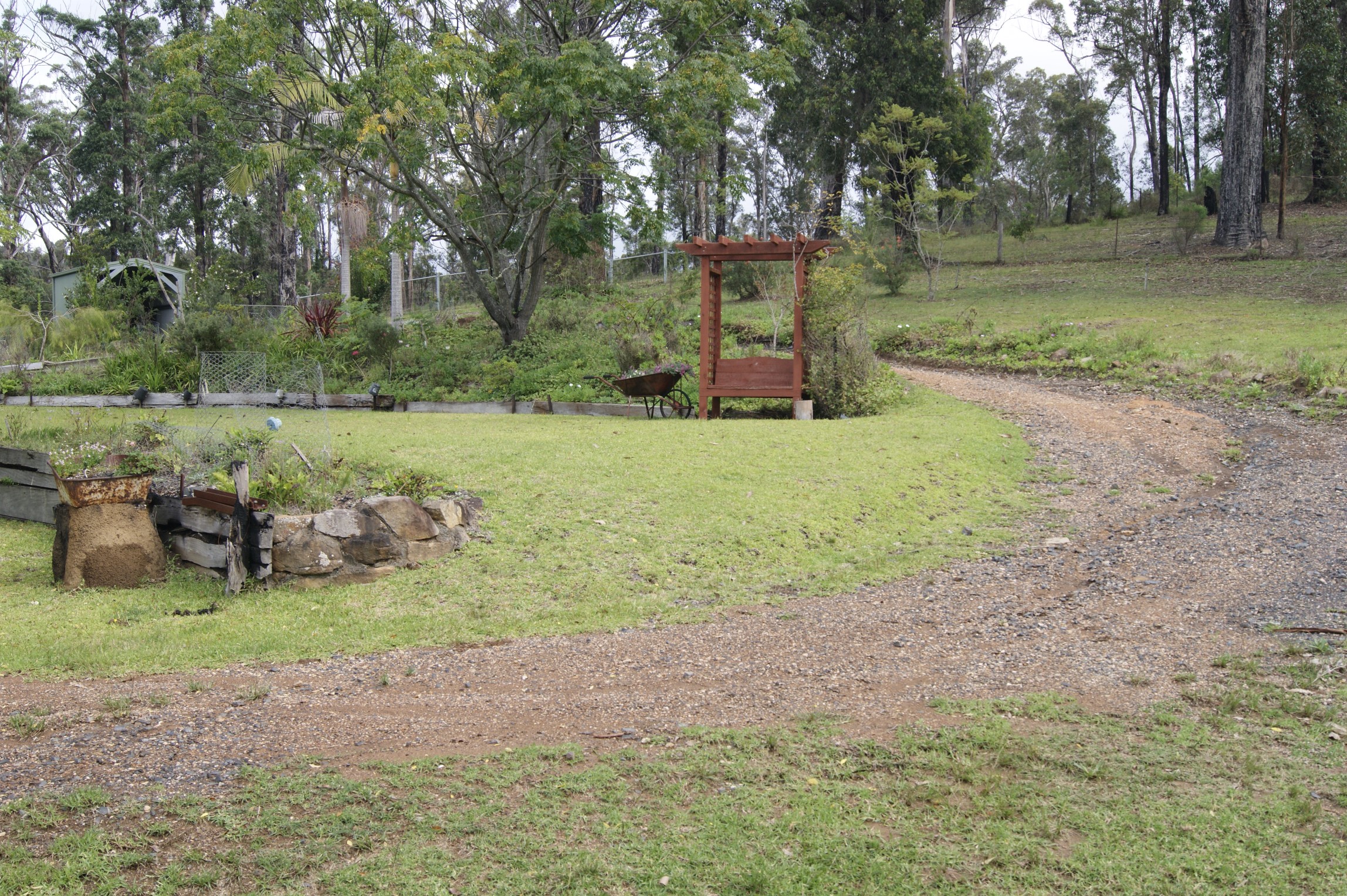 A view of the yard with a dirt track and house to the right