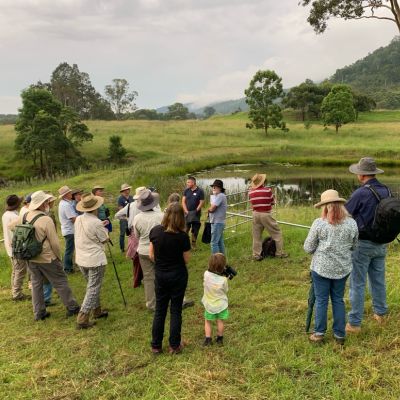 A group of people stand outside near a dam 